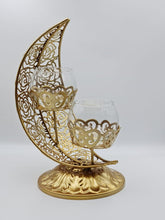 Load image into Gallery viewer, This Ramadan light up your home with this beautiful and elegant candle holder. The metal holder is in the shape of the Crescent Moon and two small candle holder sits in the middle.

